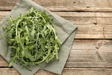 Photo of Fresh ripe green arugula leaves on wooden table, top view. Space for text