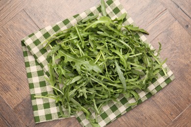 Photo of Fresh ripe green arugula leaves on wooden table, top view