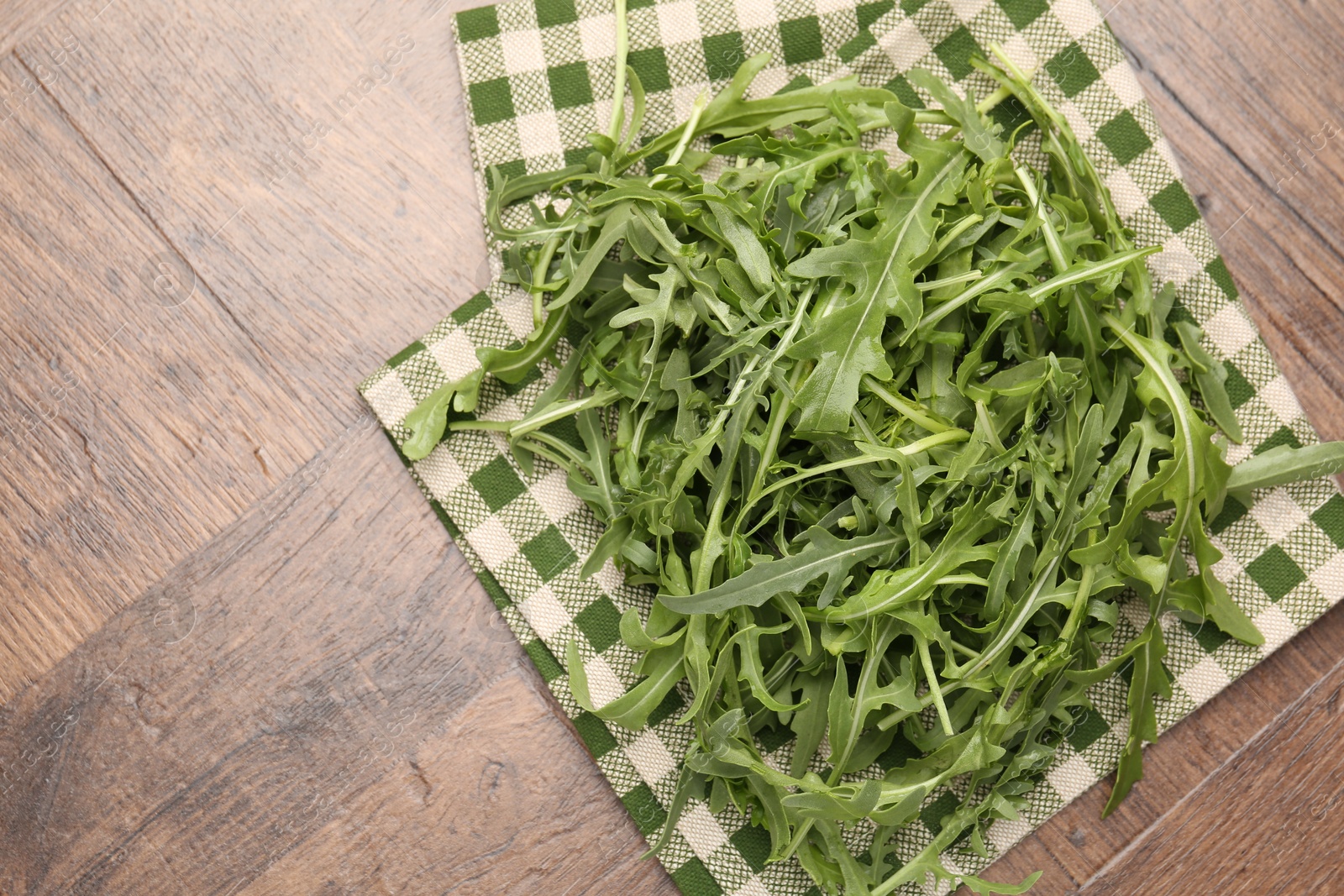 Fresh ripe green arugula leaves on wooden table, top view. Space for text Photo of Fresh ripe green arugula leaves on wooden table, top view. Space for text