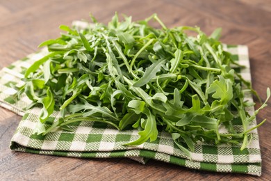 Photo of Fresh ripe green arugula leaves on wooden table, closeup