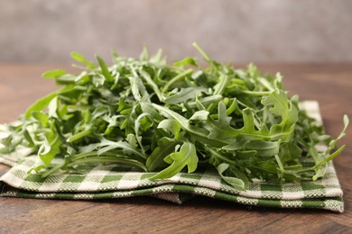 Photo of Fresh ripe green arugula leaves on wooden table, closeup
