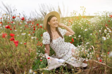 Photo of Smiling woman in hat enjoying nature in wildflower meadow