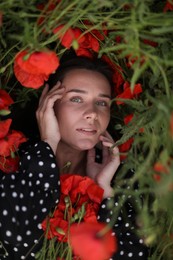Photo of Beautiful woman among red poppy flowers in wildflower meadow, above view