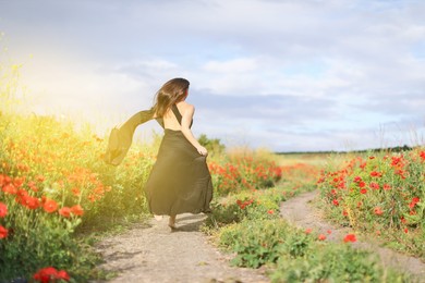 Photo of Woman running in morning wildflower meadow, back view