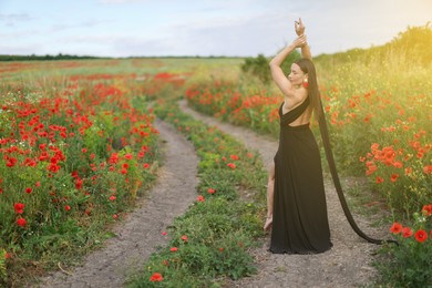 Photo of Beautiful woman in dress posing in wildflower meadow