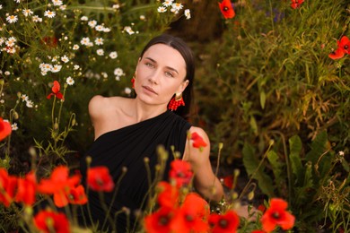 Photo of Portrait of beautiful woman among wildflowers in meadow