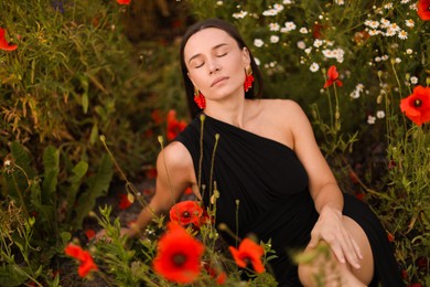 Photo of Beautiful woman posing among wildflowers in meadow