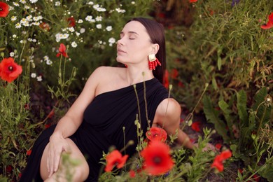Photo of Beautiful woman posing among wildflowers in meadow