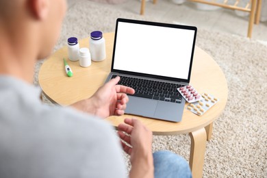 Photo of Man having online consultation with doctor via laptop at home, above view