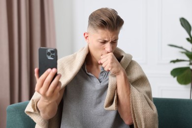 Photo of Man having online consultation with doctor via smartphone at home