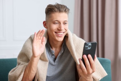 Photo of Man having online consultation with doctor via smartphone at home