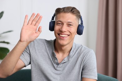 Photo of Man in headphones having online consultation with doctor at home
