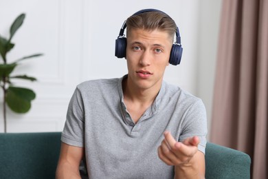 Photo of Man in headphones having online consultation with doctor at home