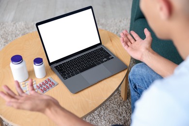 Photo of Man having online consultation with doctor via laptop at home, above view