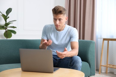 Photo of Sick man having online consultation with doctor via laptop at home