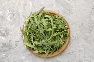 Photo of Fresh ripe green arugula leaves on grey table, top view