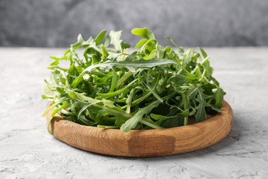 Photo of Fresh ripe green arugula leaves on grey table, closeup