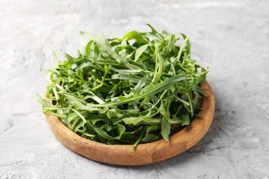 Photo of Fresh ripe green arugula leaves on grey table, closeup