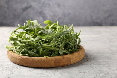 Photo of Fresh ripe green arugula leaves on grey table, closeup