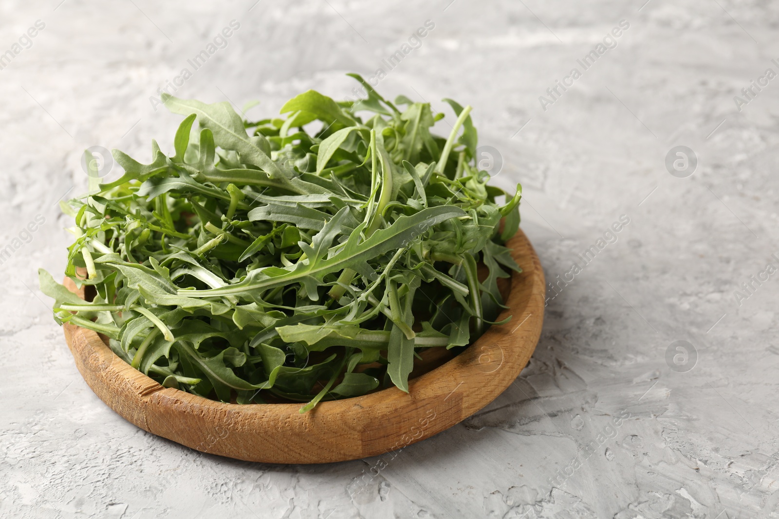 Fresh ripe green arugula leaves on grey table, closeup Photo of Fresh ripe green arugula leaves on grey table, closeup
