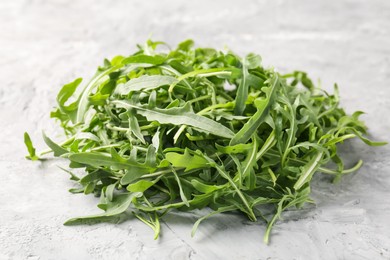 Photo of Fresh ripe green arugula leaves on grey table, closeup