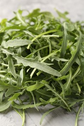 Photo of Fresh ripe green arugula leaves on grey table, closeup