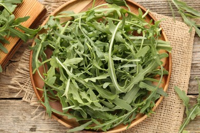 Photo of Fresh ripe green arugula leaves on wooden table, flat lay