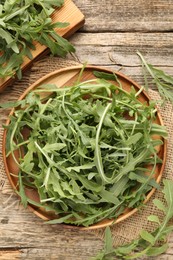 Photo of Fresh ripe green arugula leaves on wooden table, flat lay