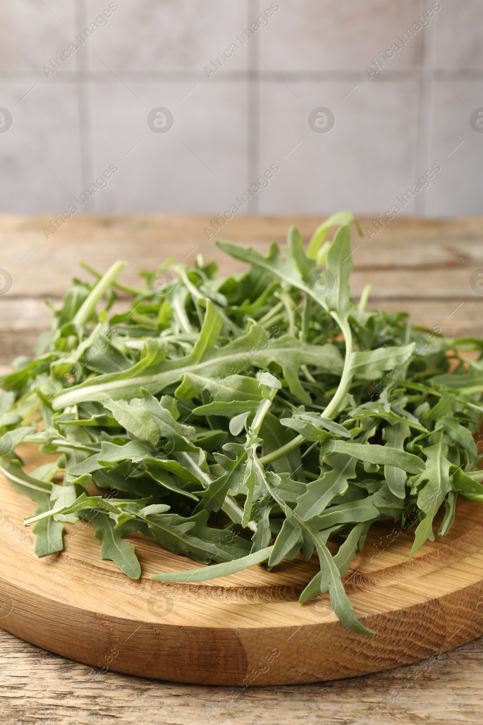 Fresh ripe green arugula leaves on wooden table, closeup Photo of Fresh ripe green arugula leaves on wooden table, closeup