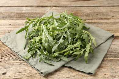 Photo of Fresh ripe green arugula leaves on wooden table, closeup