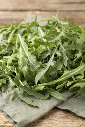 Photo of Fresh ripe green arugula leaves on wooden table, closeup