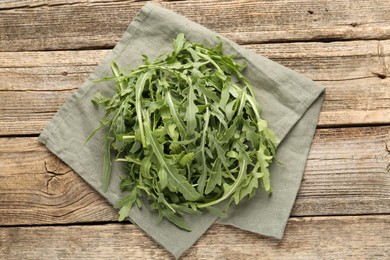 Photo of Fresh ripe green arugula leaves on wooden table, top view
