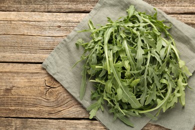Photo of Fresh ripe green arugula leaves on wooden table, top view. Space for text