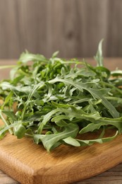 Photo of Fresh ripe green arugula leaves on table, closeup