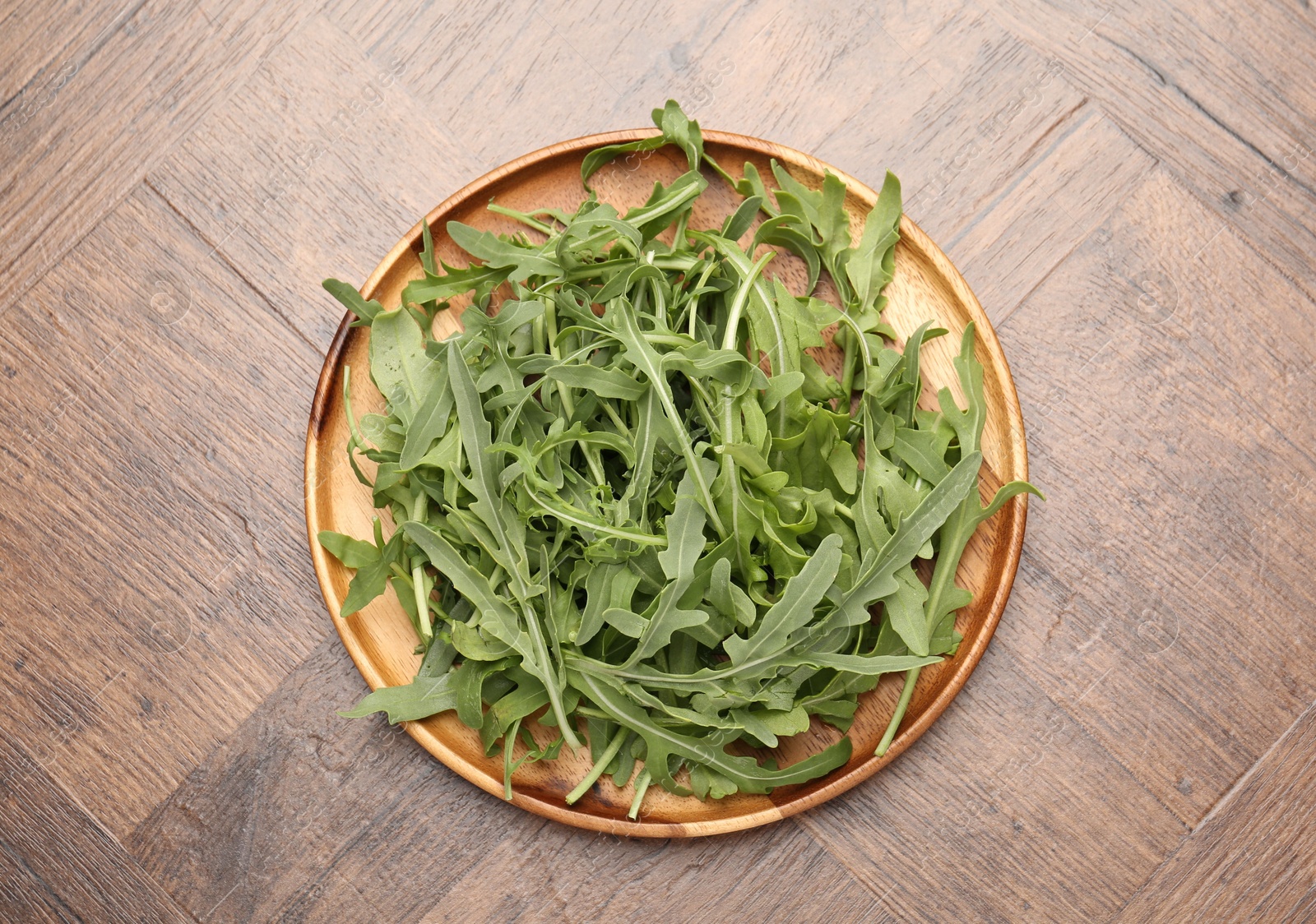 Fresh ripe green arugula leaves on wooden table, top view Photo of Fresh ripe green arugula leaves on wooden table, top view