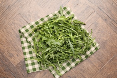 Photo of Fresh ripe green arugula leaves on wooden table, top view