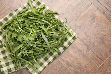 Photo of Fresh ripe green arugula leaves on wooden table, top view. Space for text