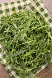 Photo of Fresh ripe green arugula leaves on wooden table, top view