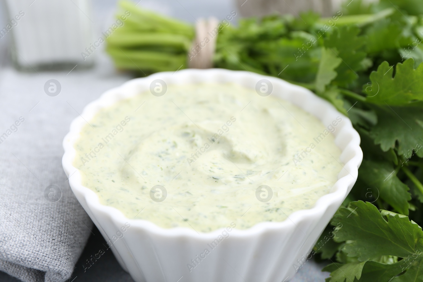 Tasty cilantro sauce in bowl on grey table, closeup Photo of Tasty cilantro sauce in bowl on grey table, closeup