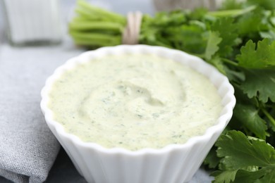 Photo of Tasty cilantro sauce in bowl on grey table, closeup