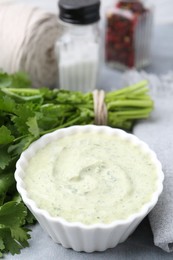 Photo of Tasty cilantro sauce in bowl on grey table, closeup