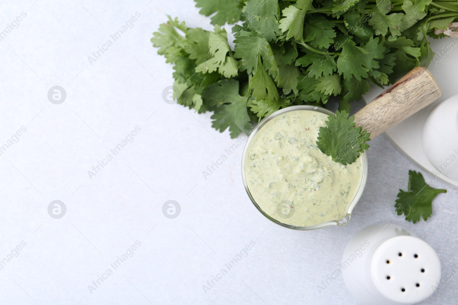 Tasty cilantro sauce on light grey table, flat lay. Space for text Photo of Tasty cilantro sauce on light grey table, flat lay. Space for text