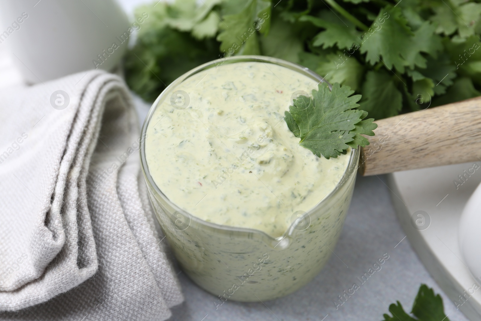 Tasty cilantro sauce on grey table, closeup Photo of Tasty cilantro sauce on grey table, closeup