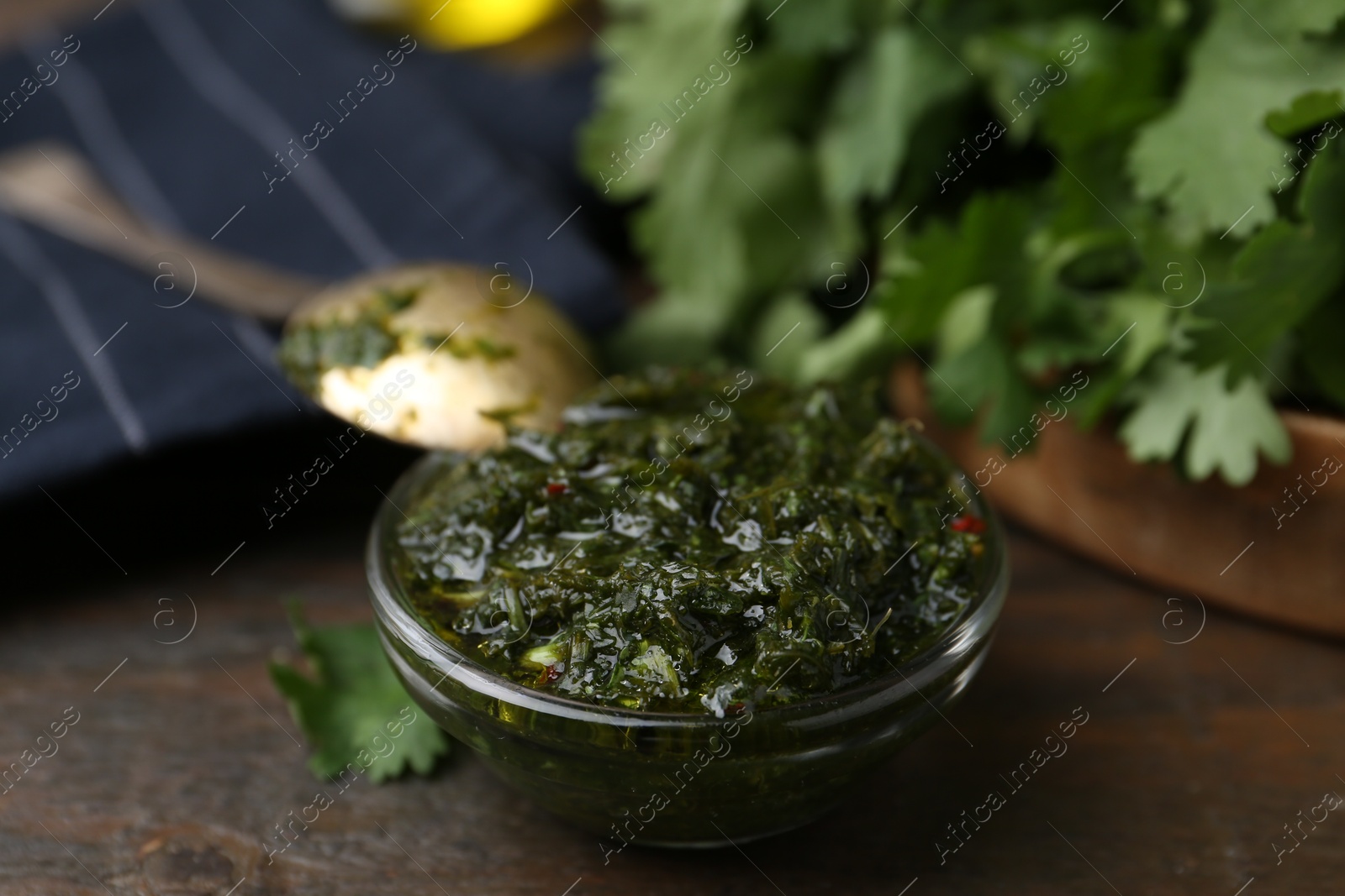 Tasty cilantro sauce in bowl on wooden table, closeup Photo of Tasty cilantro sauce in bowl on wooden table, closeup