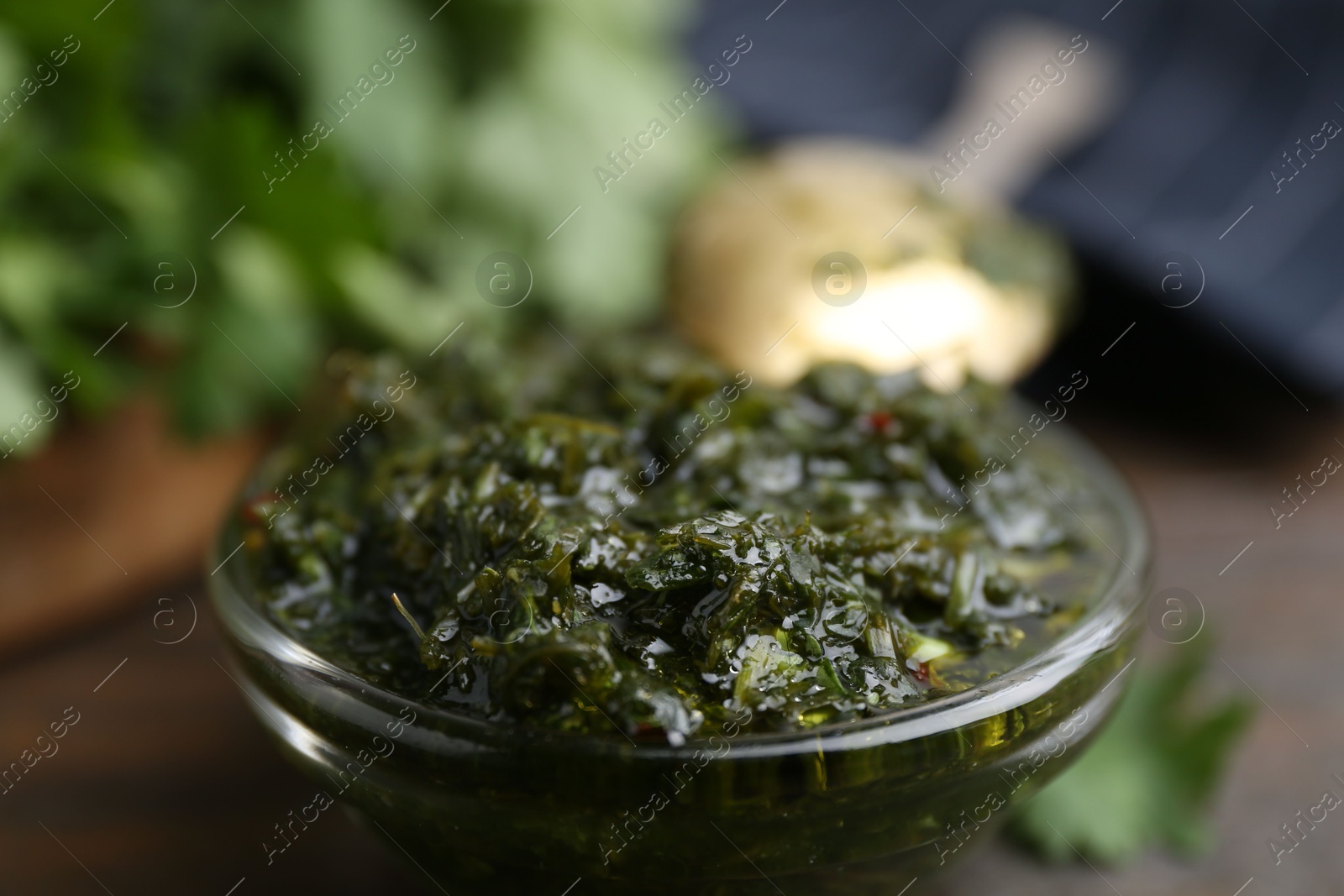 Tasty cilantro sauce in bowl on brown table, closeup Photo of Tasty cilantro sauce in bowl on brown table, closeup