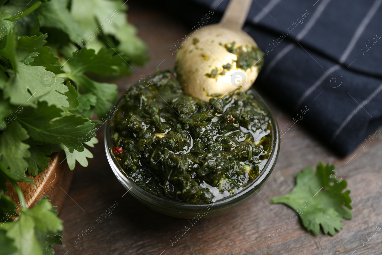 Tasty cilantro sauce in bowl on wooden table, closeup Photo of Tasty cilantro sauce in bowl on wooden table, closeup