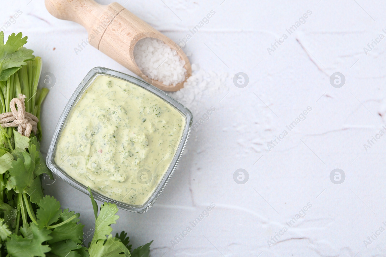 Tasty cilantro sauce in bowl and salt on light textured table, flat lay. Space for text Photo of Tasty cilantro sauce in bowl and salt on light textured table, flat lay. Space for text