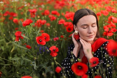 Photo of Beautiful woman among red poppy flowers in wildflower meadow