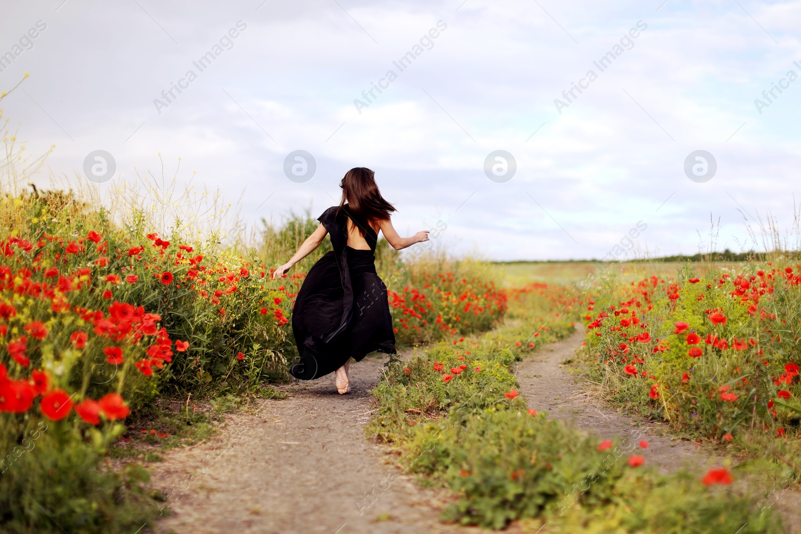 Woman running in beautiful wildflower meadow, back view Photo of Woman running in beautiful wildflower meadow, back view
