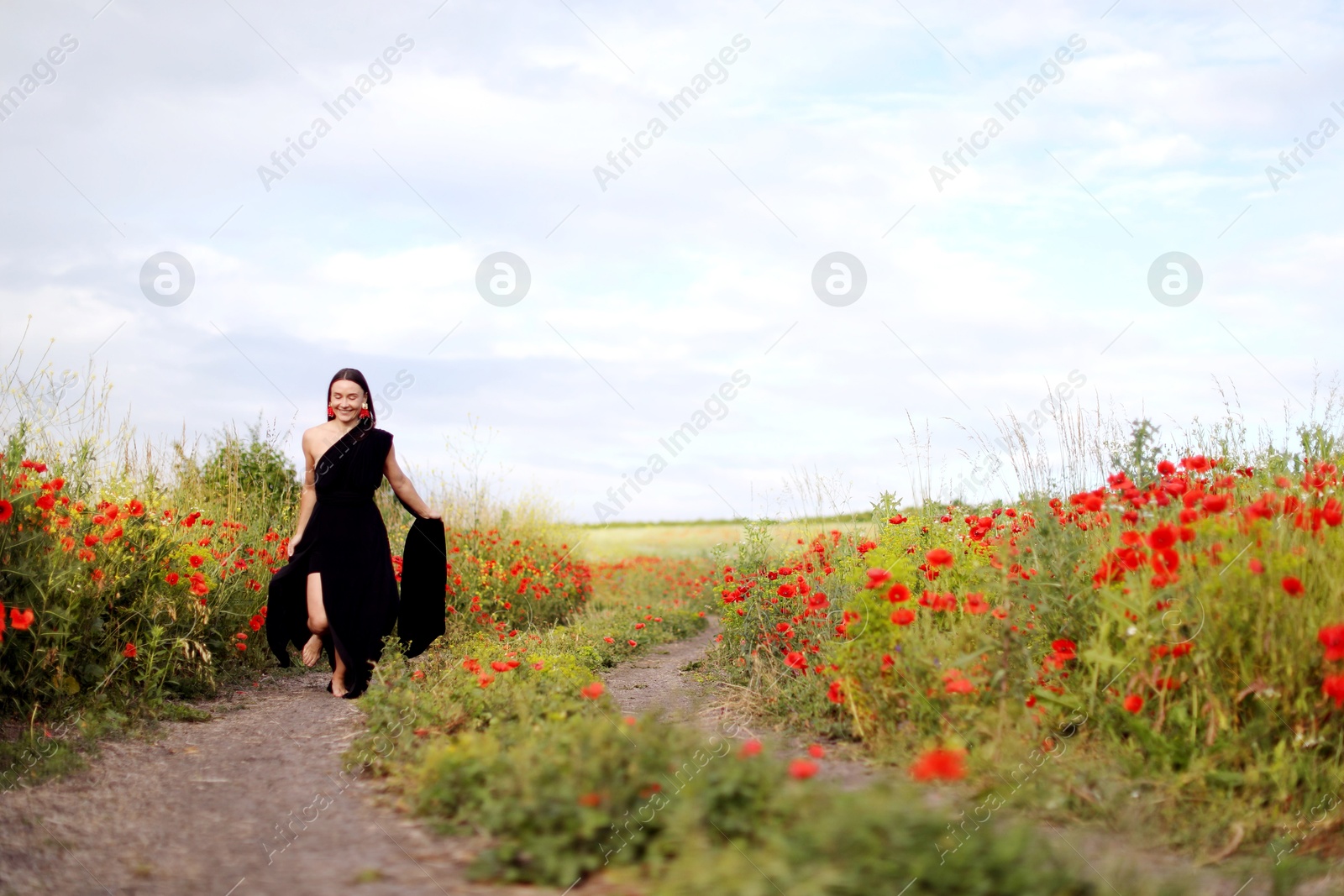 Photo of Smiling woman running in beautiful wildflower meadow